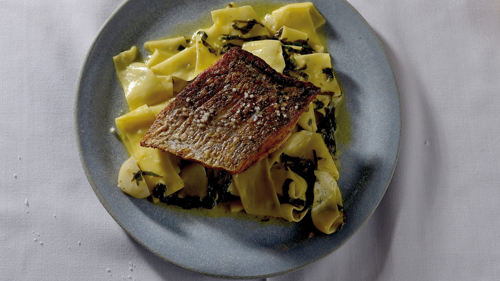 Crispy-skin fish over pappardelle